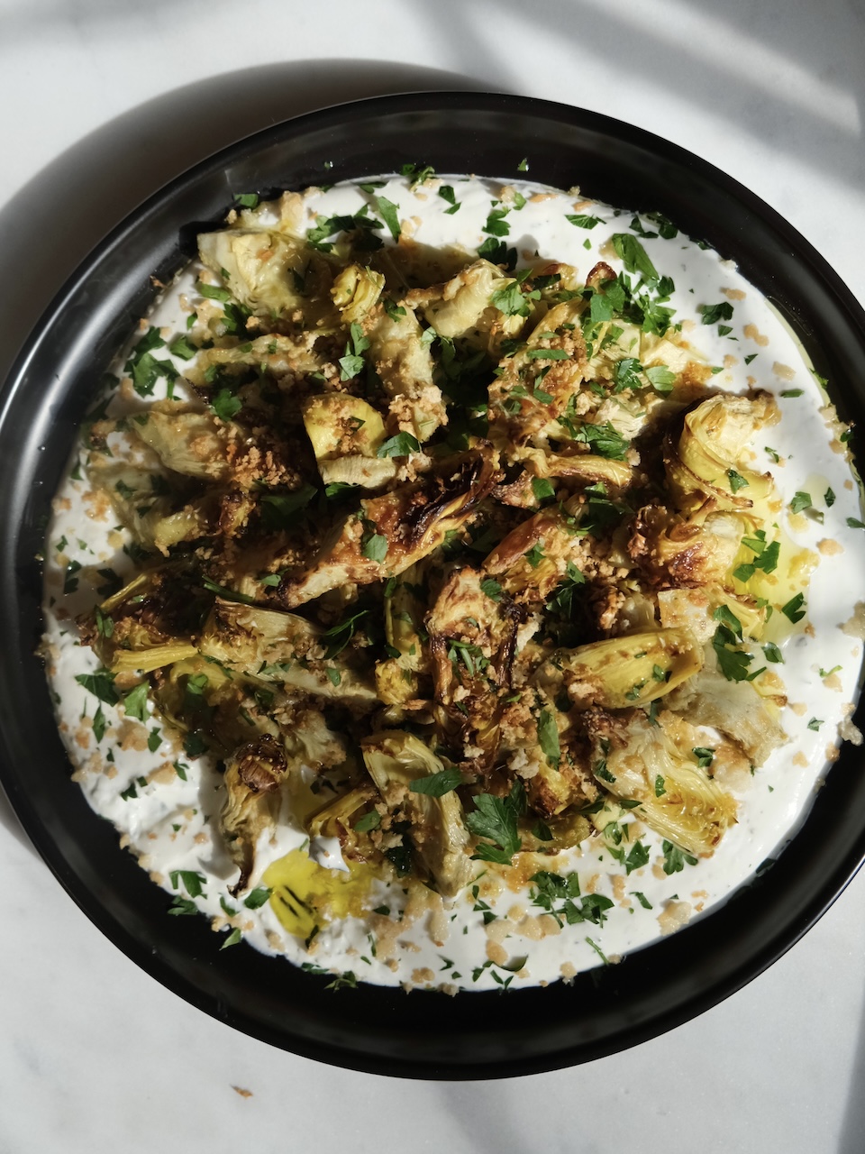 plate of crispy artichoke hearts over labneh