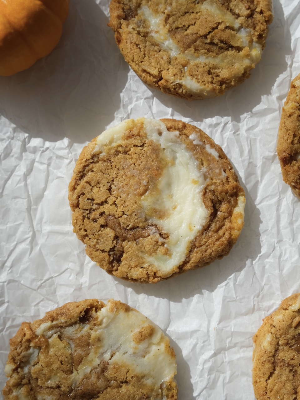 pumpkin cheesecake cookie on a sheet of parchment paper