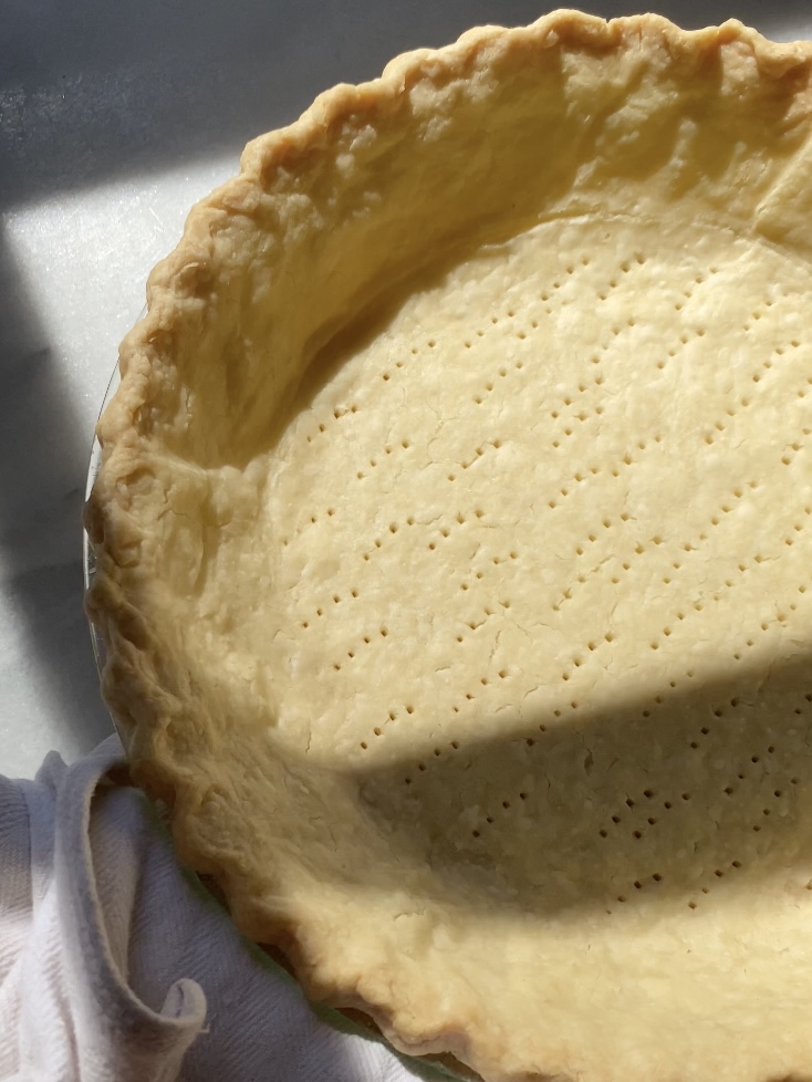 golden brown pie dough baked in a pie plate